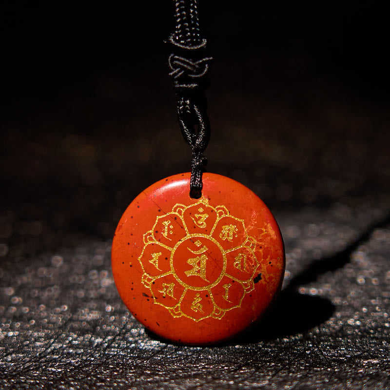 Om Mani Padme Hum Necklace – Cinnabar red pendant with gold mantra at low angle on dark stone, Tibetan necklace