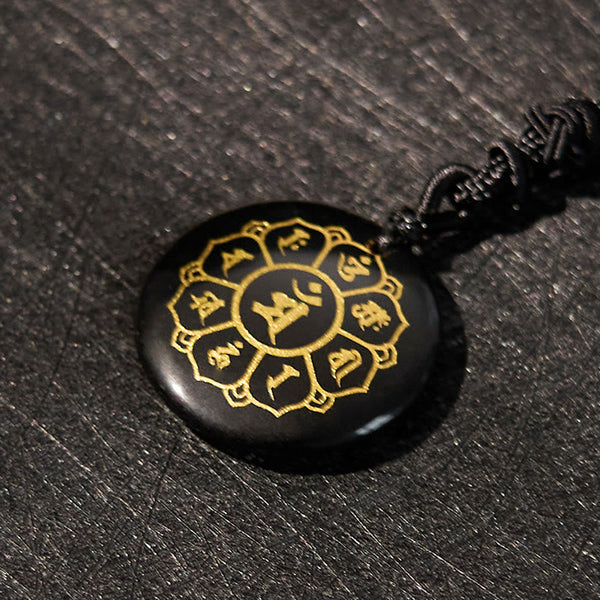 Om Mani Padme Hum Necklace – Oblique close-up of black obsidian pendant with gold Sanskrit mandala, obsidian jewelry
