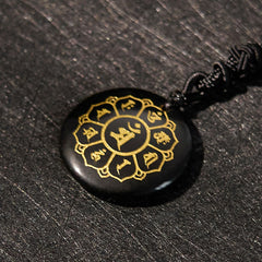 Om Mani Padme Hum Necklace – Oblique close-up of black obsidian pendant with gold Sanskrit mandala, obsidian jewelry