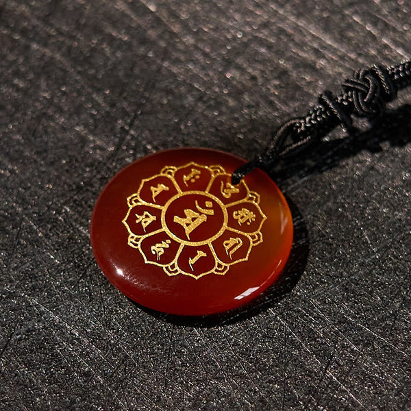 Om Mani Padme Hum Necklace – Carnelian at elevated angle showing dome on dark, orange crystal amulet