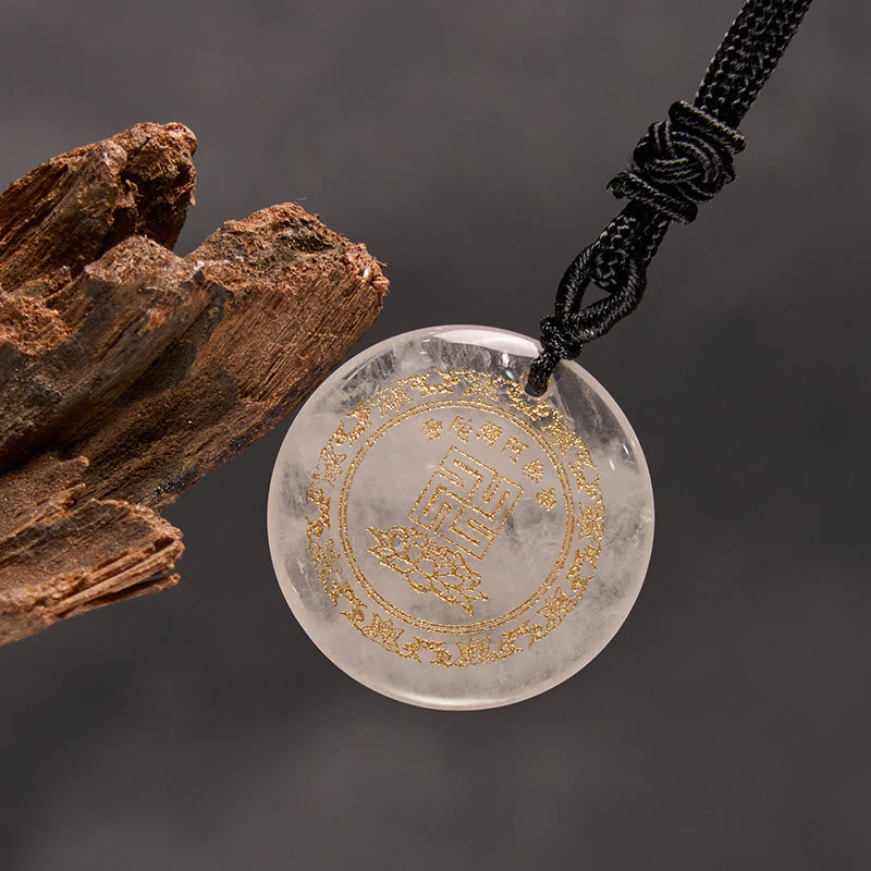Clear Crystal Purification Pendant - transparent stone with gold seal & lotus, on gray backdrop with driftwood, refined