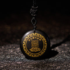 Black Obsidian Multi-Crystal Purification Pendant - low-angle view on dark slate, gold swastika & lotus on glossy obsidian, spiritual