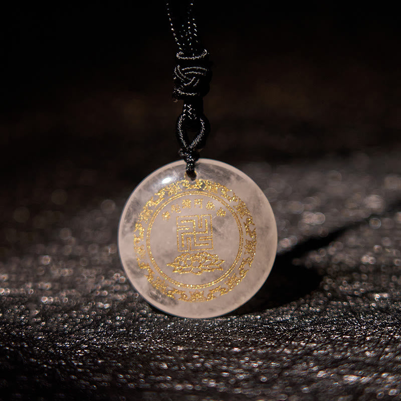 Rose Quartz Purification Pendant - translucent pink stone with gold swastika & lotus, on dark fabric, warm intimate lighting
