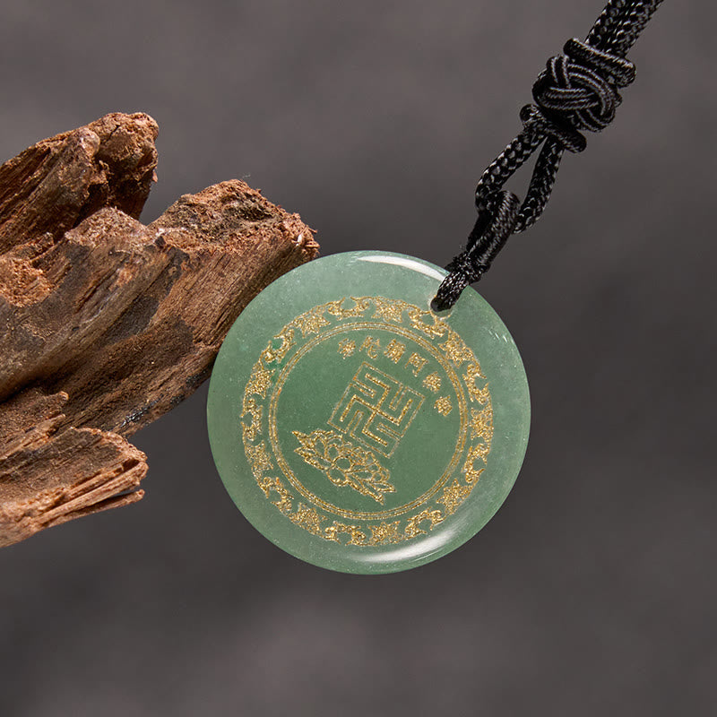 Green Jade Purification Pendant - aventurine stone gold Buddhist symbols, gray backdrop with bark prop, spiritual