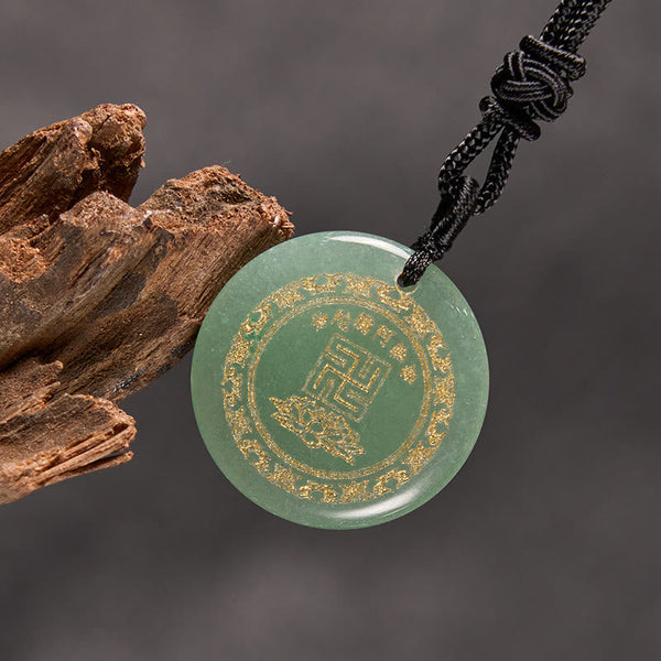 Green Jade Purification Pendant - aventurine stone gold Buddhist symbols, gray backdrop with bark prop, spiritual