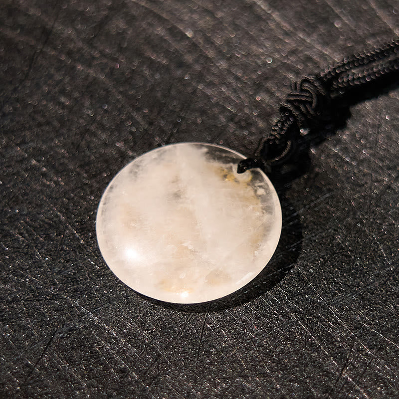 White Crystal Purification Pendant - macro detail of translucent stone natural inclusions, dark woven fabric, luminous