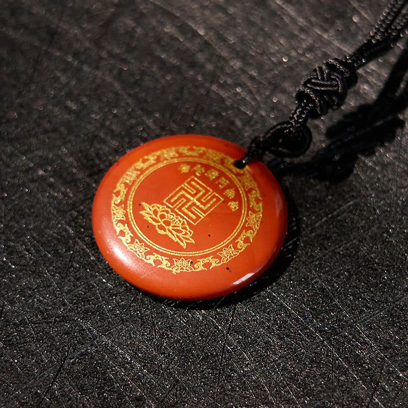 Cinnabar Purification Pendant - orange-red stone gold lotus detail, dark woven fabric bg, mystical mood