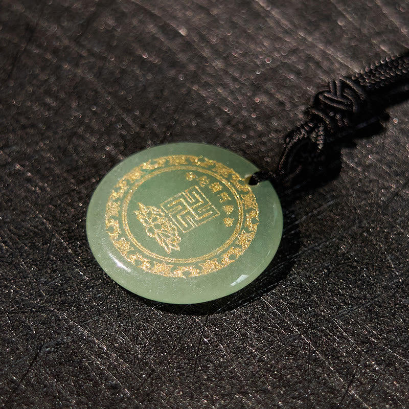 Green Jade Purification Pendant - olive jade with gold mantra border, on pebbled dark leather, warm chiaroscuro