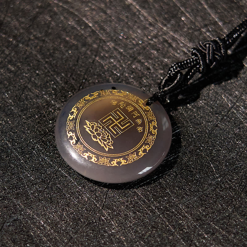 Gray Agate Purification Pendant - smoky taupe stone gold Buddhist border, dark woven fabric, elegant shadow