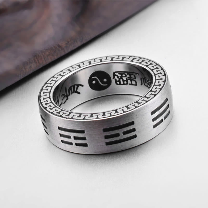 Bagua Ring - Three-quarter view of engraved trigram band with yin-yang inner and wood prop