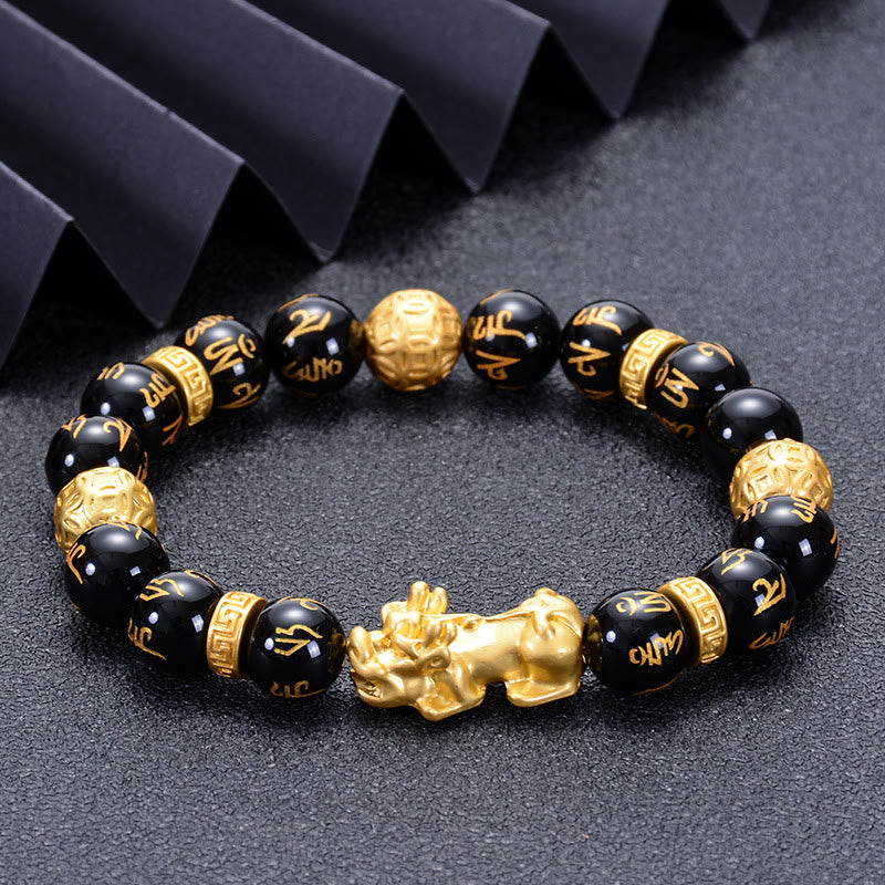 Black Obsidian PiXiu Om Mani Padme Hum Bracelet – on dark textured surface with black ribbon, angled view, spiritual jewelry