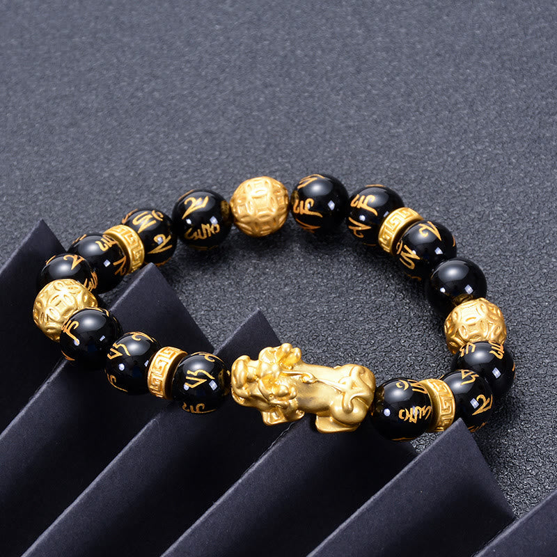 Black Obsidian PiXiu Om Mani Padme Hum Bracelet – on dark surface with black geometric props, side angle, feng shui bracelet