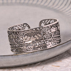 Hollow Lotus Silver Plated Copper Bracelet Bangle – silver openwork lotus on gray ceramic dish, spiritual