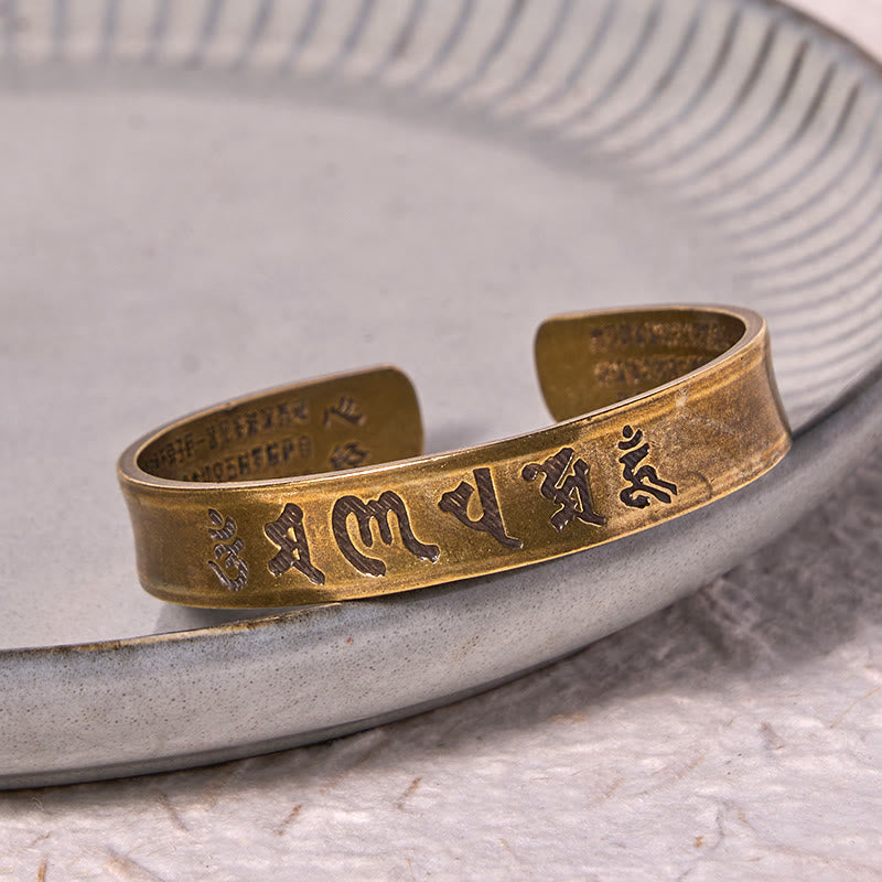 Om Mani Padme Hum Copper Cuff Bangle – Close-up on ceramic plate showing etched mantra details
