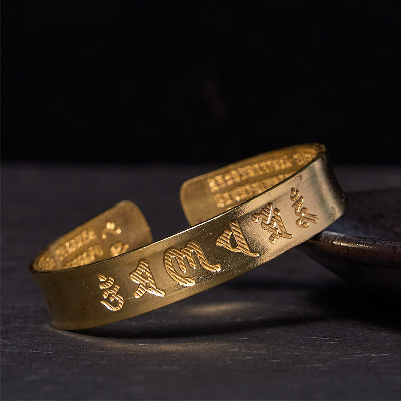 Om Mani Padme Hum Copper Cuff Bangle – Polished gold finish with raised Tibetan script, studio shot