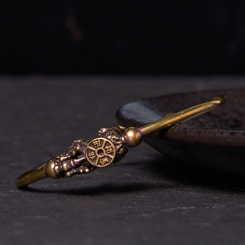 PiXiu Copper Bangle – Antique brass cuff with PiXiu and compass charm on dark plate side view