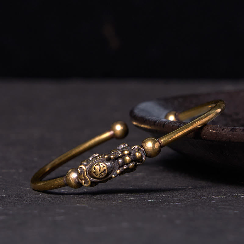 PiXiu Copper Bangle – Detailed side view of PiXiu on brass cuff with dark background