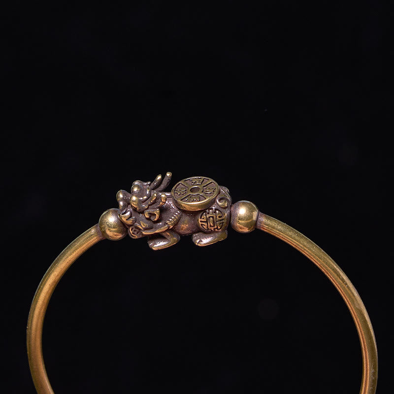 PiXiu Copper Bangle – Close-up of PiXiu compass detail on brass cuff against black
