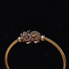 PiXiu Copper Bangle – Close-up of PiXiu compass detail on brass cuff against black