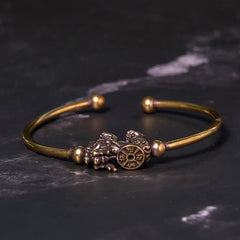 PiXiu Copper Bangle – Open cuff brass bracelet with PiXiu compass on black marble surface