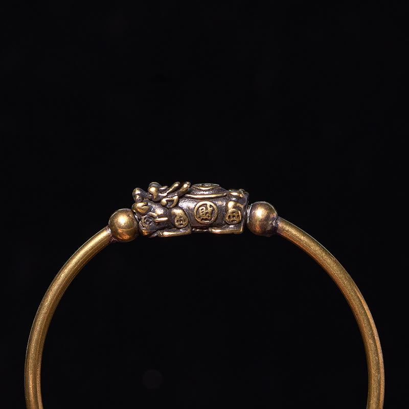 PiXiu Copper Bangle – Top close-up of PiXiu Fu character brass cuff against black