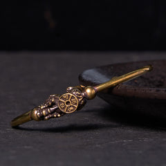 PiXiu Copper Bangle – Antique brass cuff with PiXiu and compass charm on dark plate side view