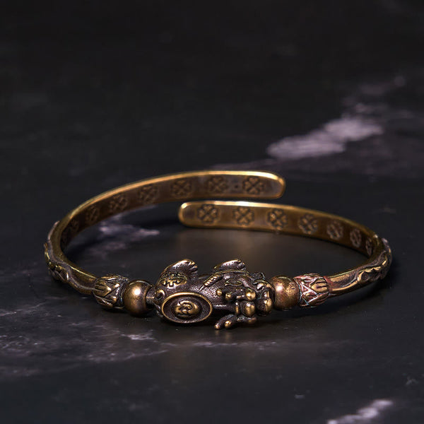 PiXiu Coin Bangle – Antique brass bangle with PiXiu coin on black marble surface