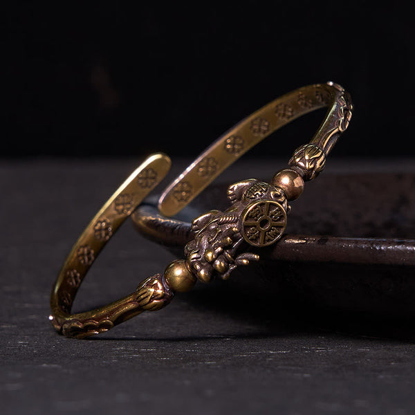 PiXiu Coin Bangle – Two stacked antique brass cuffs with PiXiu coin detail on dark surface