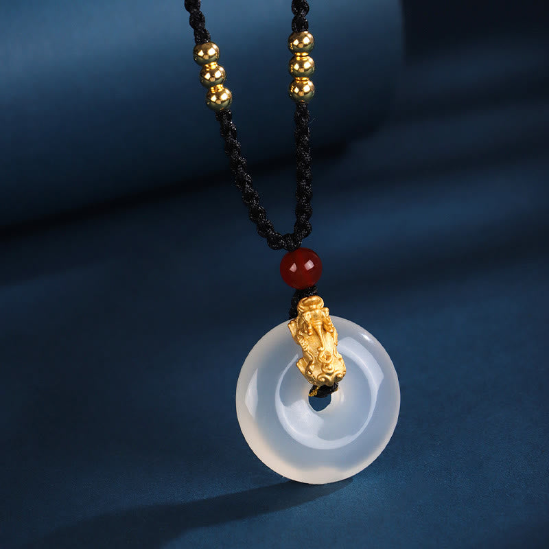 Black Onyx Agate Peace Buckle PiXiu Necklace – white agate peace buckle with gold PiXiu red bead, blue fabric background