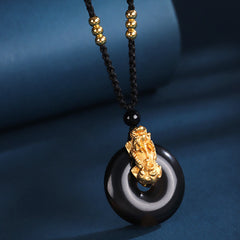 Black Onyx Agate Peace Buckle PiXiu Necklace – black onyx peace buckle with gold PiXiu cord, blue fabric background
