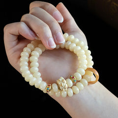Bodhi Seed Lotus Bracelet – worn on wrist showing carved lotus centerpiece and gold gemstone accents, natural grace