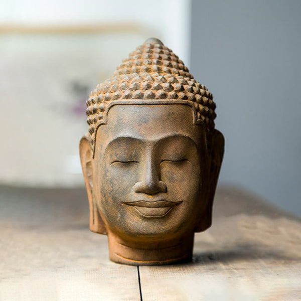 Meditating Buddha Head Resin Statue – light and shadow play on rust surface, dramatic photography