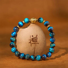 Blue Green Red Tiger Eye Buddha Bracelet – On wrist showing blue hawk eye sheen, mesmerizing chatoyancy