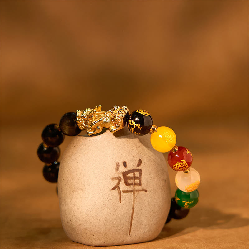 Gold Sheen Obsidian PiXiu Bracelet – on ceramic pot, warm brown background, gold PiXiu and colorful god beads