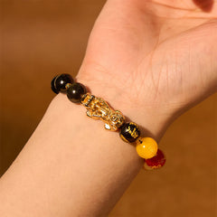 Gold Sheen Obsidian PiXiu Bracelet – worn on wrist with gold PiXiu, warm lighting, five directions gods bead