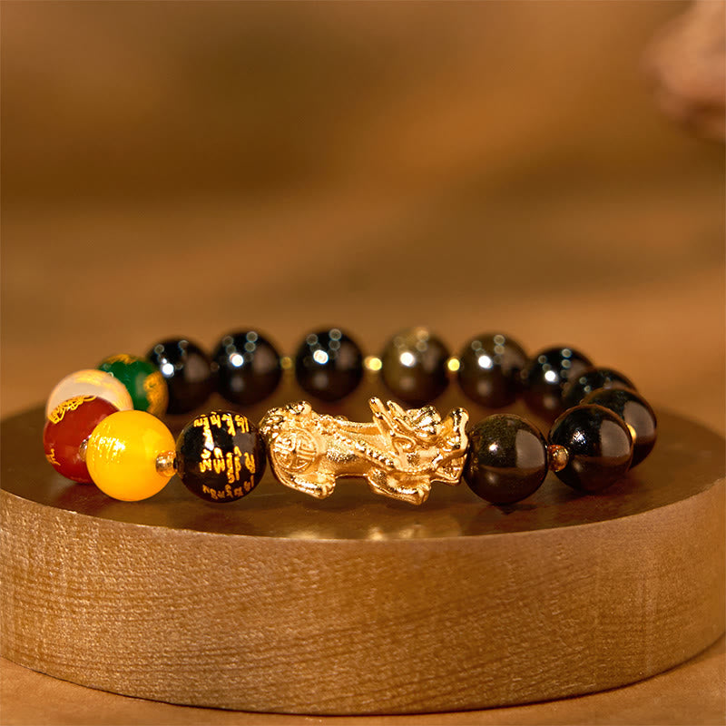 Gold Sheen Obsidian PiXiu Bracelet – side view on round wood stand, black beads with gold PiXiu, warm glow