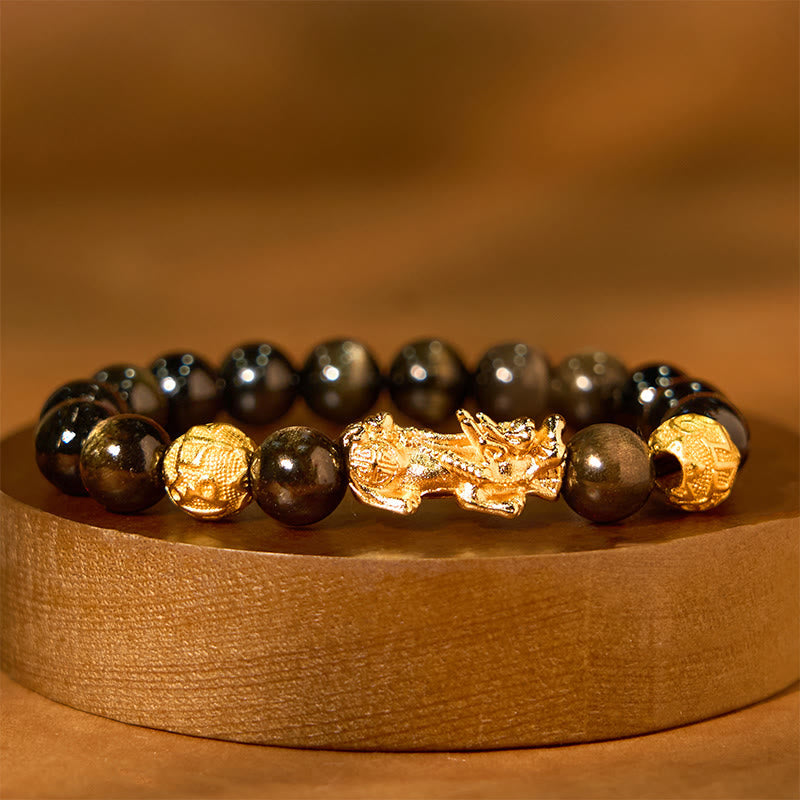 Gold Sheen Obsidian PiXiu Bracelet – Black golden-sheen beads with gold PiXiu on wood stand, wealth jewelry