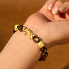 Gold Sheen Obsidian PiXiu Bracelet – Female hand wearing bracelet with gold PiXiu charm, luxury jewelry