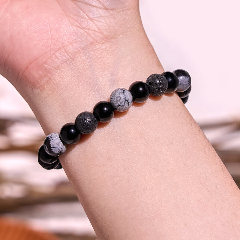 Black Obsidian Lava Rock Yin Yang Bracelet - worn on wrist close-up, bokeh background, natural stone beads