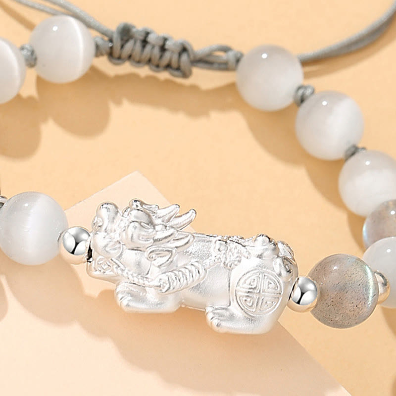 Black Obsidian Pi Xiu Bracelet – Close-up of silver Pi Xiu on white cat eye beads, detailed carving, adjustable bracelet