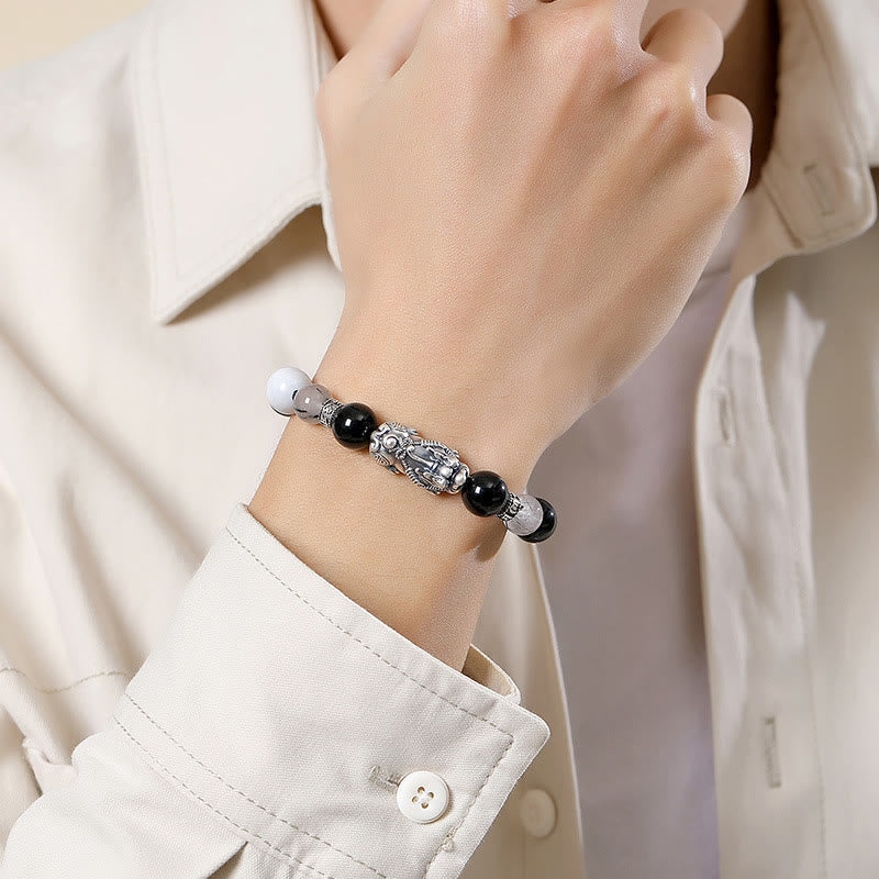 Black Obsidian Pi Xiu Bracelet – Worn on woman's wrist with white shirt, adjustable black cord, wealth bracelet