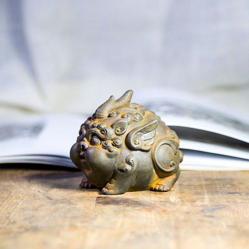 Handmade PiXiu Iron Powder Rust Cast Resin Wealth Statue – Side profile of rusted PiXiu with wing details, book background