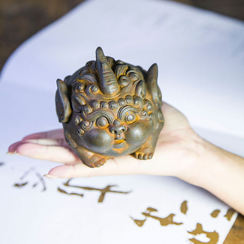 Handmade PiXiu Iron Powder Rust Cast Resin Wealth Statue – Hand holding rusted PiXiu over white paper with calligraphy