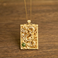 Dragon Hetian Jade Necklace | Strength – gold dragon relief pendant with green jade cabochon on wood, bold
