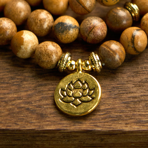 Mala Picture Jasper Lotus Bracelet - gold lotus charm detail on wood, courageous
