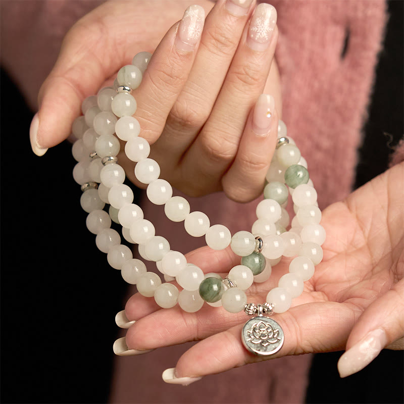 108 Mala Tianshan Jade Lotus Bracelet - cradled in both hands over pink knit, lotus pendant, serene