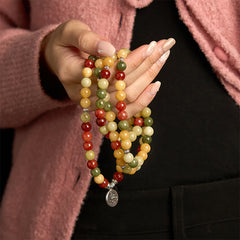 108 Mala Topaz Jasper Lotus Bracelet - held in hand against pink cardigan, warm bohemian styling