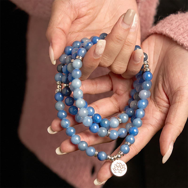 108 Mala Blue Aventurine Lotus Calm Bracelet – cupped hands holding blue stone strands with lotus medallion, Peaceful