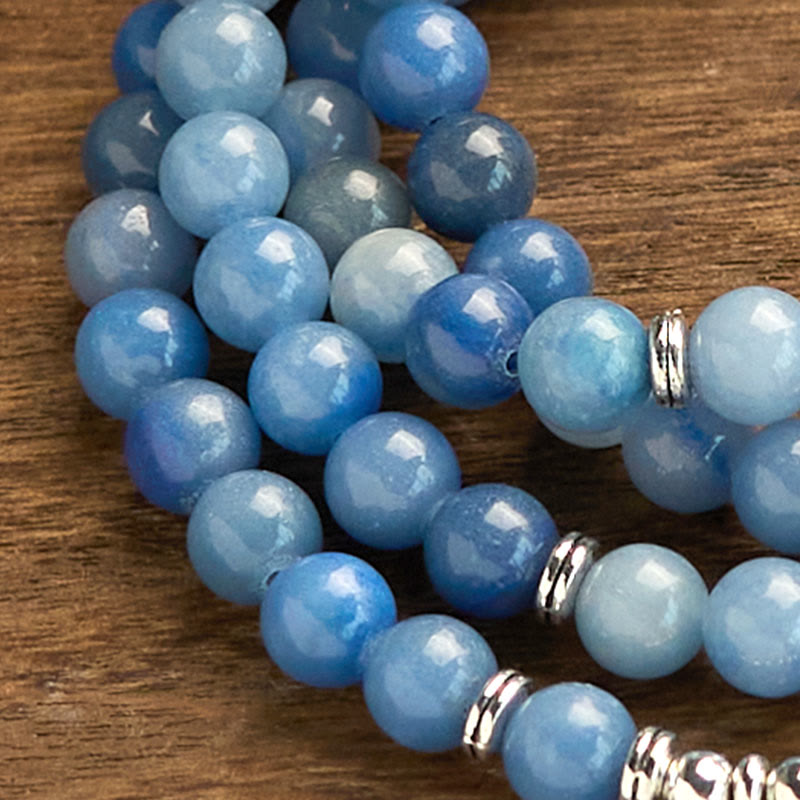 108 Mala Blue Aventurine Lotus Calm Bracelet – coiled blue gemstone beads with silver spacers on rustic wood, Focus
