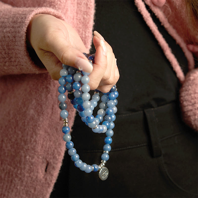 108 Mala Blue Aventurine Lotus Calm Bracelet – long blue mala necklace with silver lotus pendant against pink knit, Focus